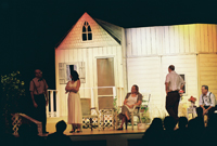 Three men and two women in front of a house