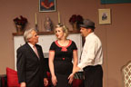 A man in a suit, a woman in a black dress and a man in a hat and tie