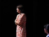 A young woman with her arms crossed talking to an older woman