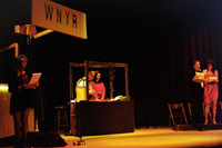 A woman at a microphone, a man and a woman in a sound effects booth, and a couple at another microphone