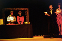 A man and a woman in a sound effects booth and a couple at a microphone