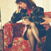 Woman with drink sitting next to man on couch