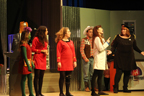 A green alien and two women in red Starfleet uniforms, a man in a cowboy hat and vest, a woman in a white lab coat and a woman in a
       black sparkly skirt