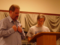 A man behind a podium and another man standing next to the podium