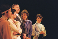 A Native American man, a woman, a man in a suit, and two more woman standing 