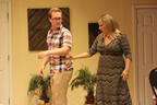 A young man wearing glasses and in a plaid shirt and his mom adjusting his shirt 