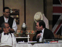 Two men sitting at a table with one man standing